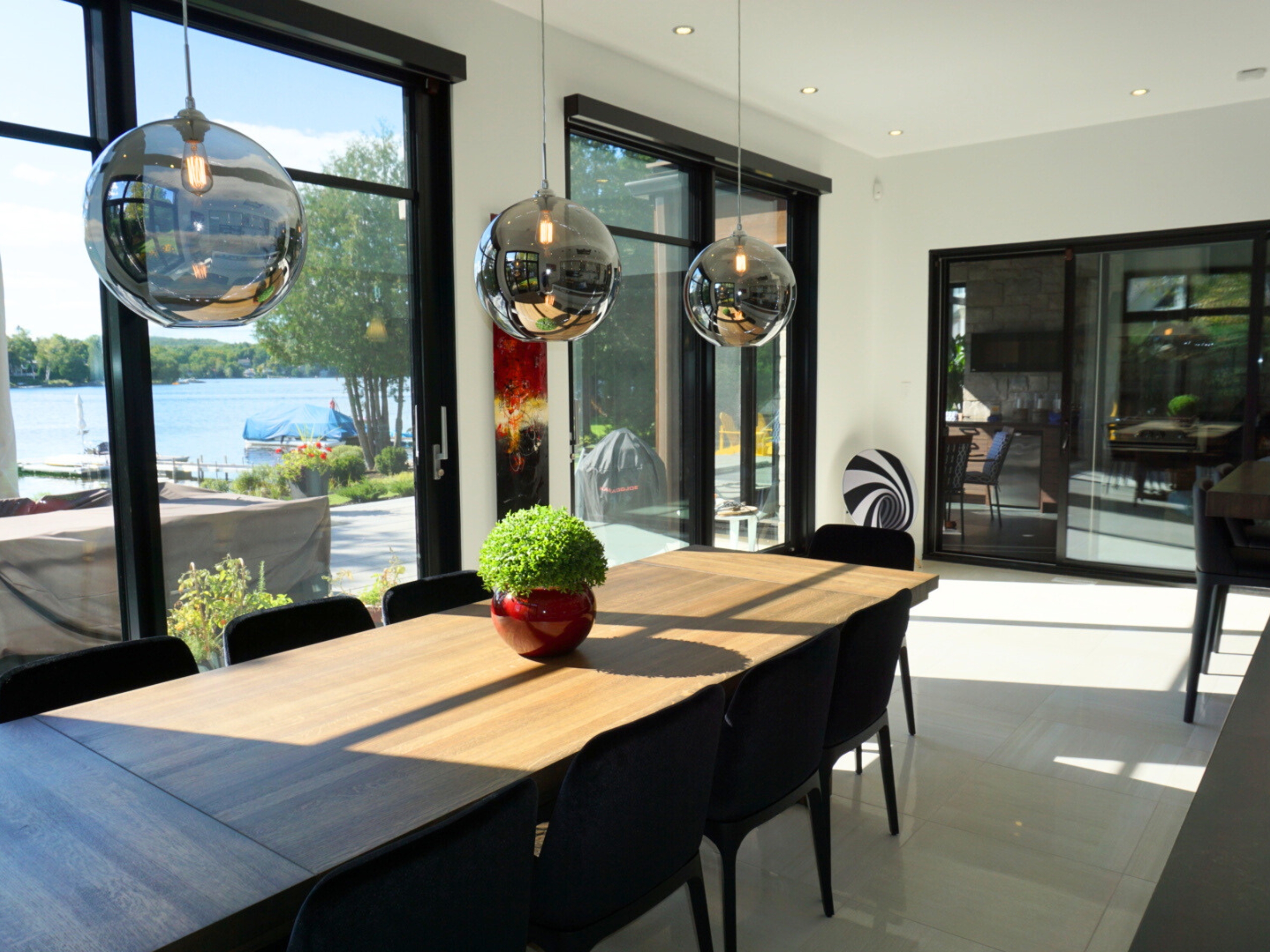 Salle à manger avec vaste fenestration et vue sur l'eau