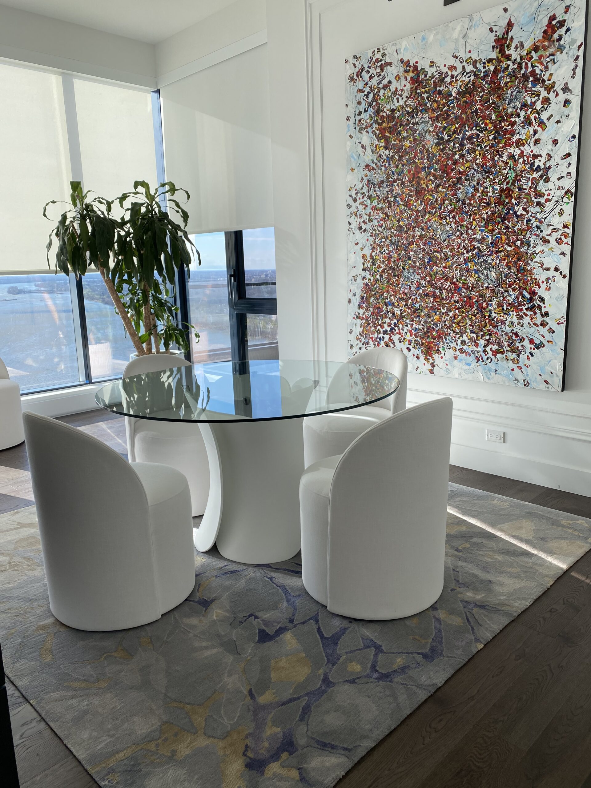 Table en verre ronde avec fauteuils en tissus blanc et tapis de sol design