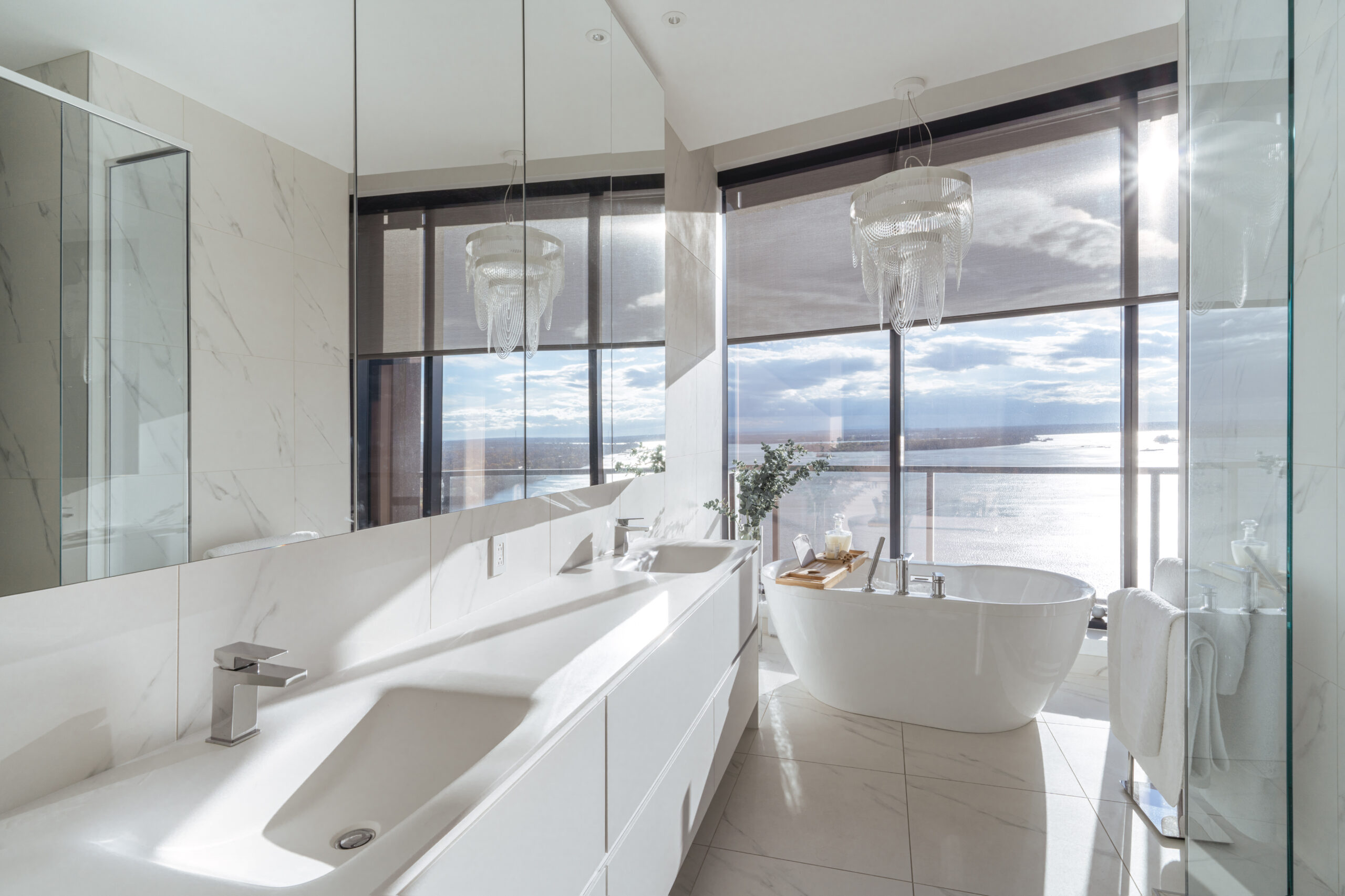 Superbe salle de bain luxueuse avec vue magnifique sur l'eau, baignoire blanche autoportante et vanité blanche